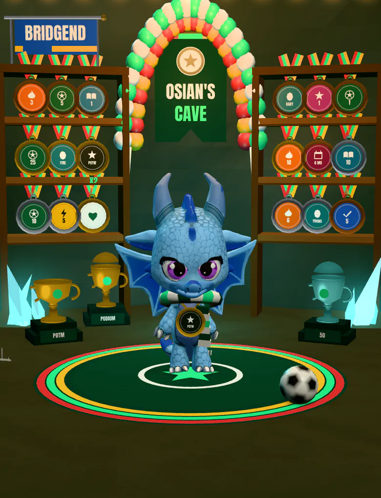 Osian’s cave in the app: a blue 3D dragon wearing a medal stands on a round stage, with shelves of medals, trophies on plinths and an area flag behind it.